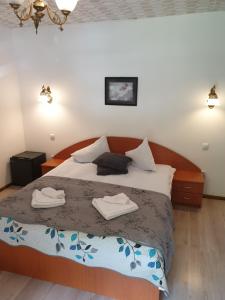 a bedroom with a bed with two towels on it at Vila Bianca Dragusin in Moieciu de Sus