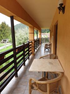 a balcony with a wooden table and chairs on it at Vila Bianca Dragusin in Moieciu de Sus