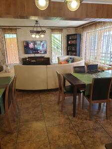 a living room with a table and chairs and a couch at Vila Bianca Dragusin in Moieciu de Sus