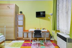 a room with a desk and a tv on a wall at Margaret Apartment in Budapest