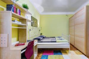 um pequeno quarto com uma cama e uma secretária em Margaret Apartment em Budapeste