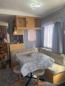 a living room with a table and a couch at 187 sealands in Ingoldmells +12 photos