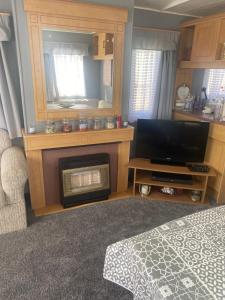 a bedroom with a fireplace and a tv and a bed at 187 sealands in Ingoldmells