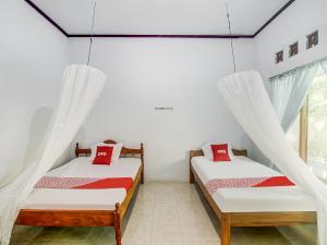 Tempat tidur dalam kamar di OYO 90924 Tarsius Homestay