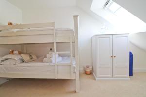 a white bunk bed in a white room at 50m FROM THE BEACH, dogs welcome in St Merryn +15 photos