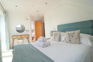 a bedroom with a bed with towels on it at 50m FROM THE BEACH, dogs welcome in St Merryn