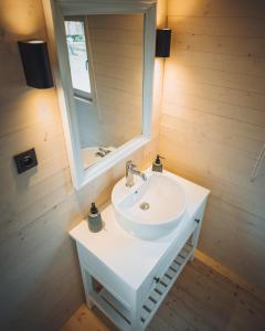 y baño con lavabo blanco y espejo. en Glamping Limburg - nabij Nationaal Park Hoge Kempen, en Kinrooi