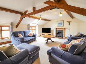 a living room with blue couches and a fireplace at The Coach House in Llanymynech