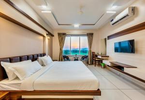 Hotel Grand Indu, 3 Star Kolhapur的电视和/或娱乐中心