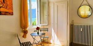 einen Tisch mit einer Blume in einem Zimmer mit einem Fenster in der Unterkunft La plus belle vue du lac Léman in Montreux