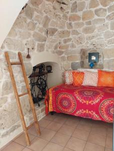 um quarto com uma cama numa parede de pedra em Trullo di Puglia em Ceglie Messapica