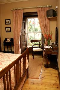 1 dormitorio con cama, ventana y escritorio en Glendine Country House Wexford, en Wexford