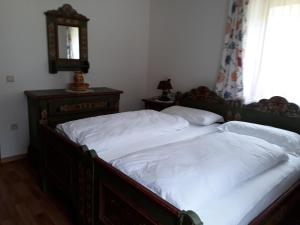 two beds in a bedroom with a mirror and a window at Althuberhof in Planca di Sopra