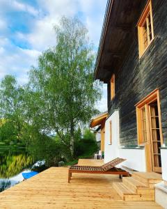 una terraza de madera con un banco en el lateral de una casa en Seehaus Walster10 en Mariazell