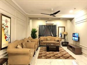 a living room with couches and a flat screen tv at The Millenial Apartments & Suites Bahria Town in Rawalpindi