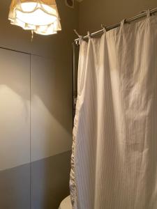 a bathroom with a white shower curtain and a light at Palazzo Nicolai in Magione