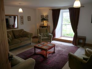 a living room with a couch and a coffee table at Old Coach House in Moniaive