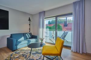 a living room with a couch and a chair and a table at Landhotel Sternwirt - Das Wellnesshotel zwischen Nürnberg und Amberg in Högen