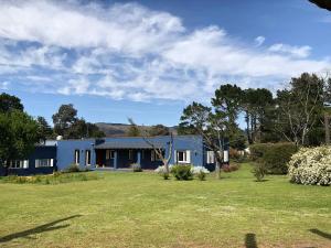 a blue house with a yard in front of it at Posada La Serena in Tandil