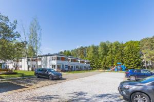 a parking lot with cars parked in front of a building at Domki Aqua Holiday in Pobierowo