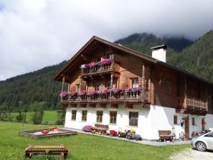 ein Haus mit Blumen auf dem Balkon in der Unterkunft Althuberhof in Planca di Sopra