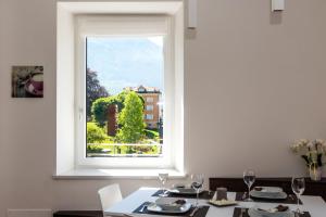 a dining room with a window and a table and chairs at Appartamento Levico in Levico Terme