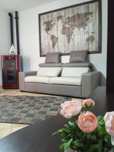GRETA'S HOUSE في Comitini: غرفة معيشة مع أريكة وطاولة مع زهور