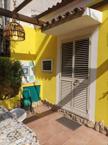 Casa amarilla con ventana y lámpara de araña. en Casa La Fornace, en La Maddalena