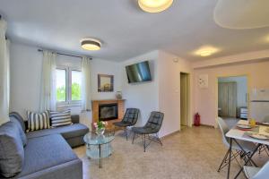 uma sala de estar com um sofá, uma mesa e cadeiras em Villa Bella Montagna em Kapíon