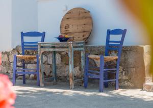 Duas cadeiras azuis e uma mesa com um espelho. em Villa Bella Montagna em Kapíon