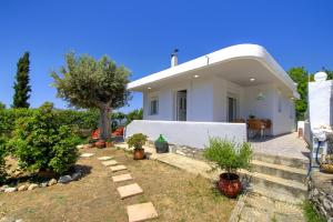 una casa blanca con un árbol en el patio en Villa Bella Montagna, en Kapíon
