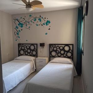 a bedroom with two beds and a chandelier at Enjoy Morro Jable in Morro del Jable