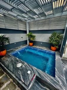 a swimming pool with plants in a building at Apartamento/villa con piscina Verdana in San Francisco de Macorís
