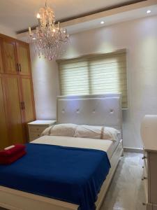 a bedroom with a large bed with a blue blanket at Apartamento/villa con piscina Verdana in San Francisco de Macorís
