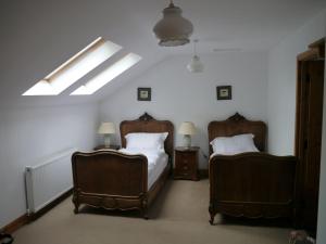 a bedroom with two beds and two chairs at Old Coach House in Moniaive