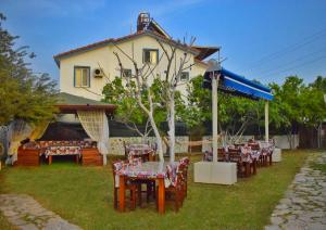 a group of tables and chairs in front of a house at ELİT OTEL in Palamutbuku