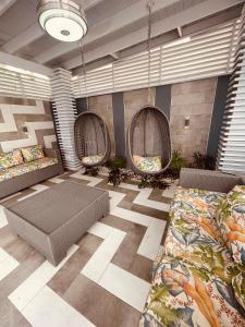 a room with three wicker chairs and couches at Apartamento/villa con piscina Verdana in San Francisco de Macorís