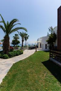 a park with a palm tree next to a building at Costa Luvi Hotel Bodrum - All Inclusive in Gümbet