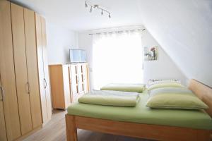 Bett mit vier Kissen auf einem Zimmer in der Unterkunft Ferienwohnung 3land Reisen in Neuenburg am Rhein
