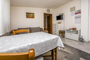 uma sala de estar com uma mesa e um sofá em Apartment Kucinic em Rogoznica