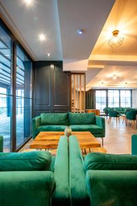 a living room with green couches and tables at Ador Hotel in Pristina