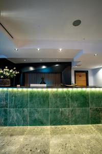 eine Lobby mit einer Arbeitsplatte aus grünem Marmor in der Unterkunft Ador Hotel in Pristina
