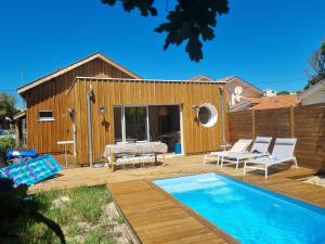 a backyard with a pool and a house at Biby BeachHouse in Lacanau