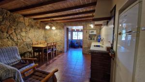 a kitchen and dining room with a table in a stone building at El Jardí de la Vileta - Cornudella de Montsant in Cornudella