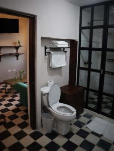uma casa de banho com WC e piso em xadrez em La Casa del General Hotel Boutique em Parral