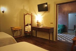 1 dormitorio con espejo, tocador y cama en La Casa del General Hotel Boutique en Hidalgo del Parral