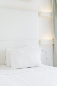 a bed with two pillows on it in a room at Costa Luvi Hotel Bodrum - All Inclusive in Gümbet