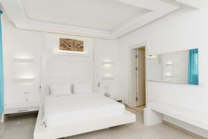 a white bedroom with a bed and a mirror at Costa Luvi Hotel Bodrum - All Inclusive in Gümbet