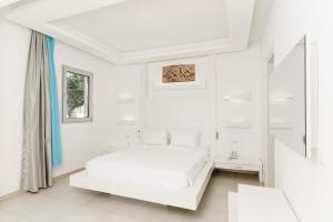 a white bedroom with a bed and a window at Costa Luvi Hotel Bodrum - All Inclusive in Gümbet