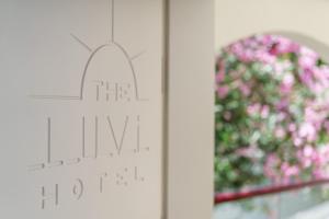 a cross on a wall next to a window with pink flowers at Costa Luvi Hotel Bodrum - All Inclusive in Gümbet